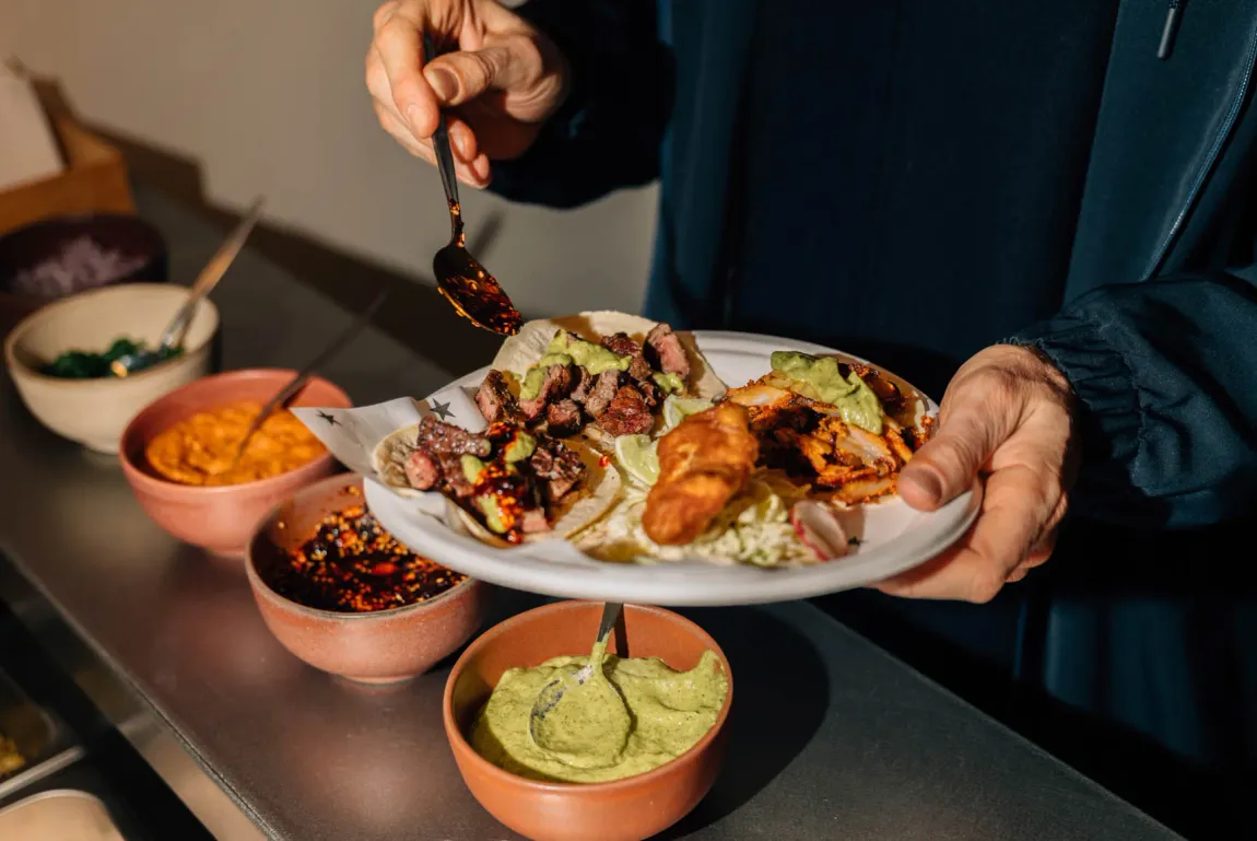 Salsa bar bowls alongside a fresh plate of tacos